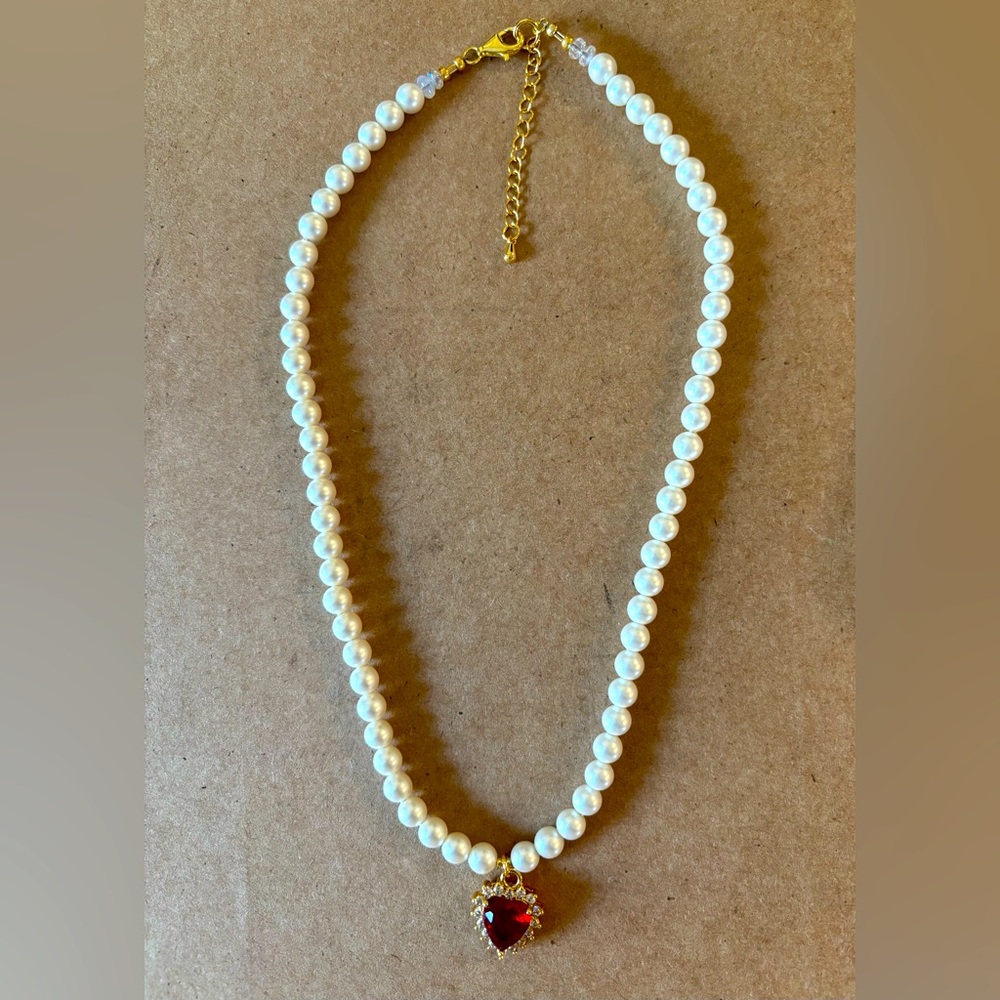 Pearl necklace with red crystal heart pendant.